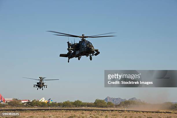 a pair of ah-64d apache longbow helicopters taking off on a mission in support of exercise angel thunder 2013. - arizona angel thunder stock pictures, royalty-free photos & images