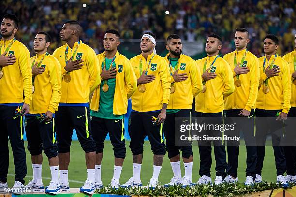 Summer Olympics: Brazil team wearing gold medals and singing the national anthem during ceremony after defeating Germany in Men's Final Gold Medal...