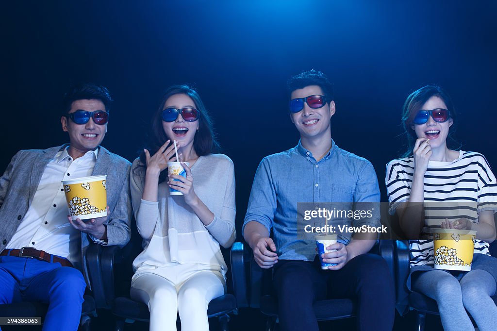 Young men and women watching movies in the cinema
