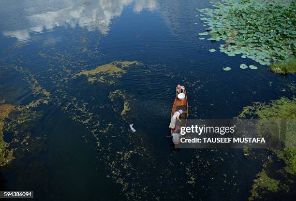 Kashmiri man rows a boat inside a Nigeen Lake in Srinagar on August 23, 2016. - Indian-administered Kashmir has been in the grip of almost daily...