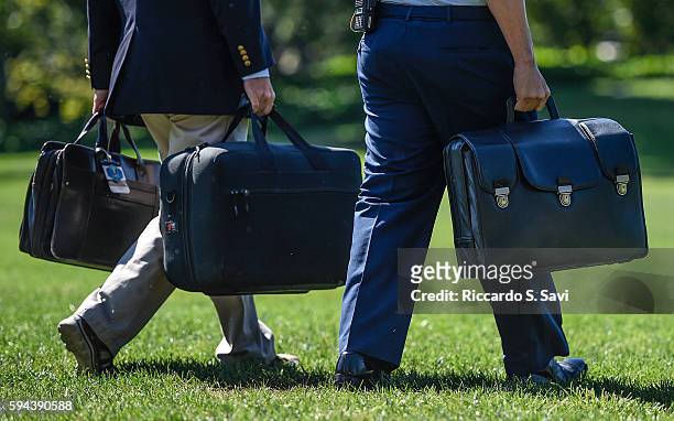 An aide to Barack Obama carries the "football", a secured briefcase that holds the nuclear codes, on August 23, 2016 in Washington, DC.