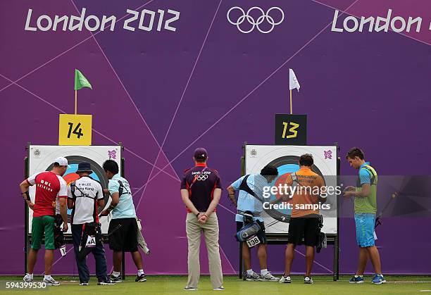 Bogenschiessen der Männer Qualifikation Archery qualifkation men Schüzte zieht die Pfeile aus der Zielscheibe Olympische Sommerspiele in London 2012...