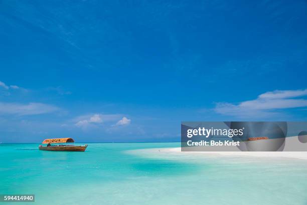 excursion boat tied up by a sandy beach - zanzibar 個照片及圖片檔