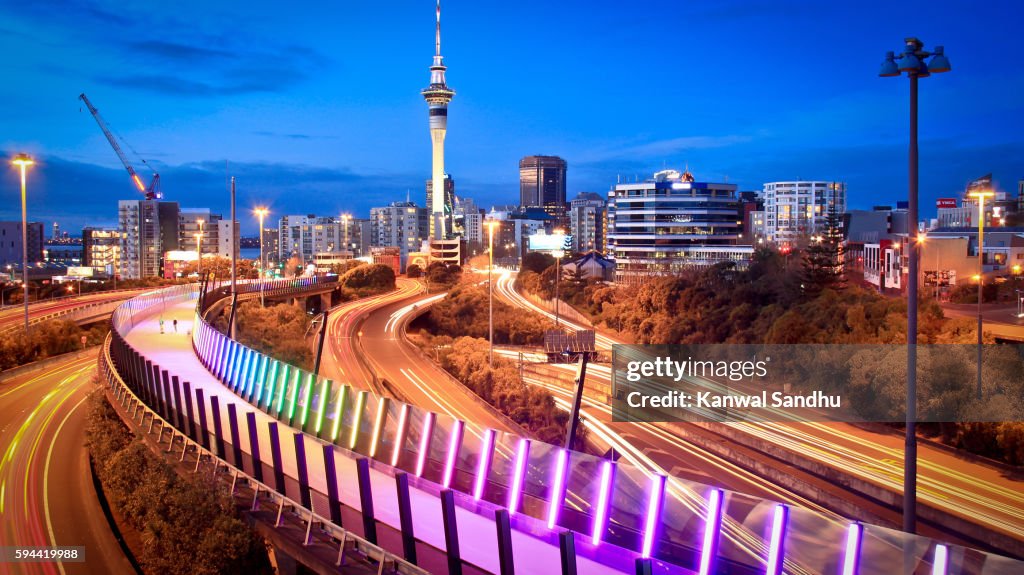 Auckland Lightpath elevated walkaway and urban skyline at dusk with Skytower in middle during evening peak hour