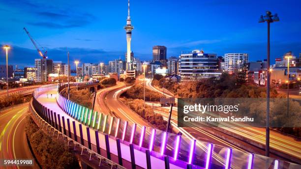 auckland lightpath elevated walkaway and urban skyline at dusk with skytower in middle during evening peak hour - auckland light path stock pictures, royalty-free photos & images