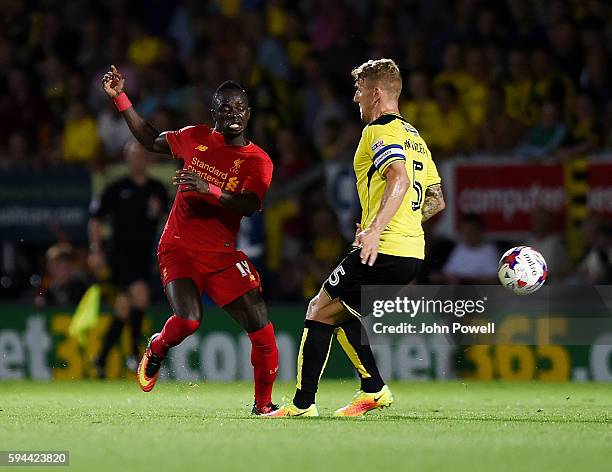 Sadio Mane of Liverpool competes with Kyle McFadzean of Burton Albion during the EFL Cup match between Burton Albion and Liverpool at the Pirelli...