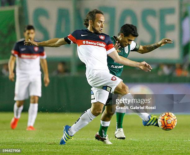 Fernando Belluschi of San Lorenzo fights for the ball with Walter Erviti of Banfield during a first leg match between Banfield and San Lorenzo as...