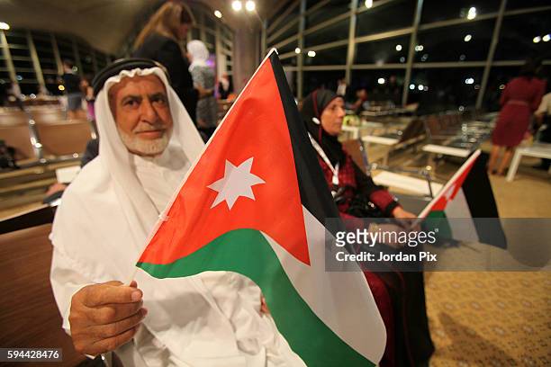 Parents of a Jordanian Olympic mission member hold the national flag during a welcome home ceremony for Jordanian Olympic gold medallist Ahmad Abu...