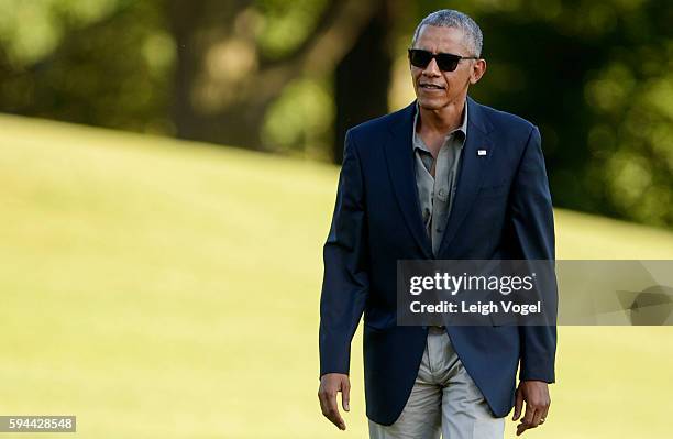 President Barack Obama walks toward the White House after exiting Marine One upon his arrival from Baton Rouge, Louisiana on August 23, 2016 in...