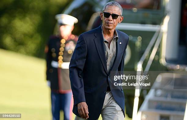 President Barack Obama walks toward the White House after exiting Marine One upon his arrival from Baton Rouge, Louisiana on August 23, 2016 in...