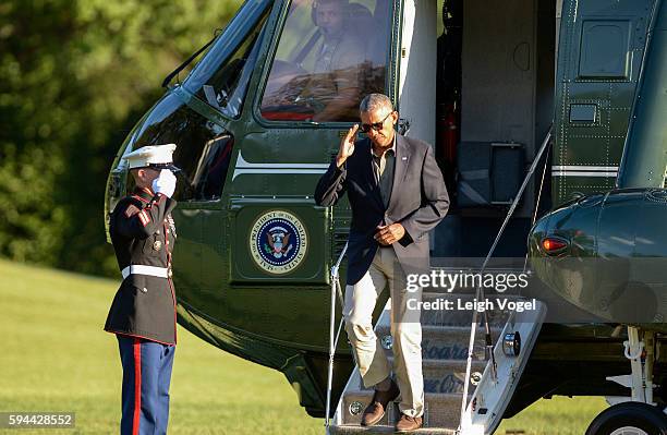 President Barack Obama salutes as he exits Marine One upon his return from Baton Rouge, Louisiana on August 23, 2016 in Washington, DC.