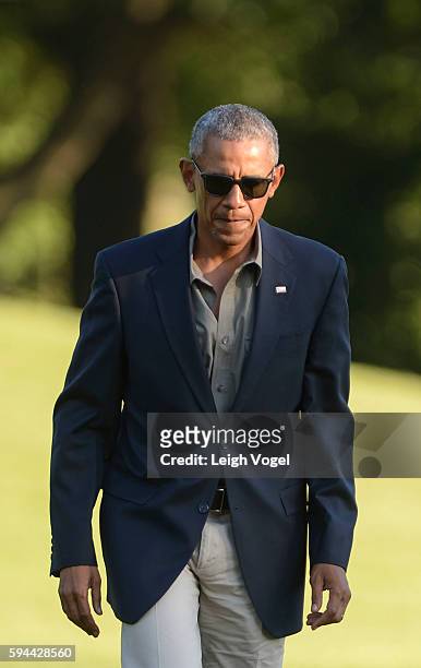 President Barack Obama walks toward the White House after exiting Marine One upon his arrival from Baton Rouge, Louisiana on August 23, 2016 in...