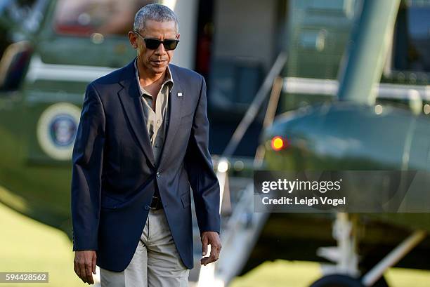 President Barack Obama walks toward the White House after exiting Marine One upon his arrival from Baton Rouge, Louisiana on August 23, 2016 in...