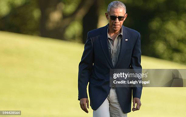 President Barack Obama walks toward the White House after exiting Marine One upon his arrival from Baton Rouge, Louisiana on August 23, 2016 in...