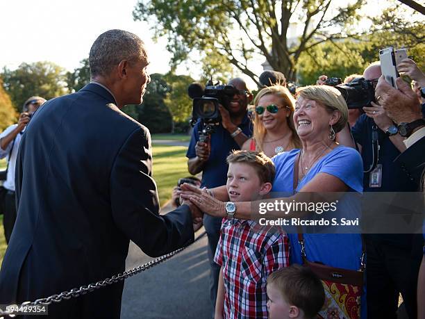 President Barack Obama greets the family of a Marine One pilot that flew his last flight today, after returning from Baton Rouge Louisiana, on August...