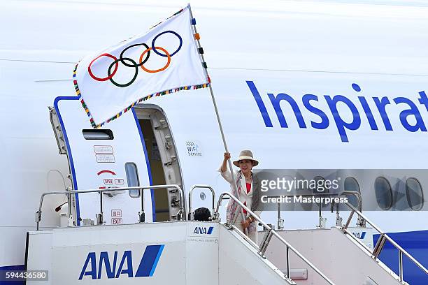 The governor of Tokyo Yuriko Koike walks out of an airplane with the Olympic flag during the "The Arrival of Olympic Flag Ceremony" at the Haneda...
