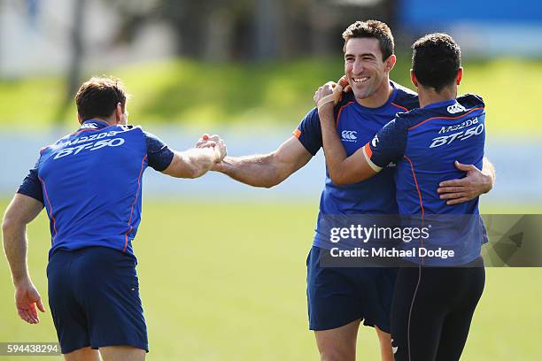 Brent Harvey of the Kangaroos and Michael Firrito , not to be re-contracted for next season by the club, get a hug from Lindsay Thomas during a North...