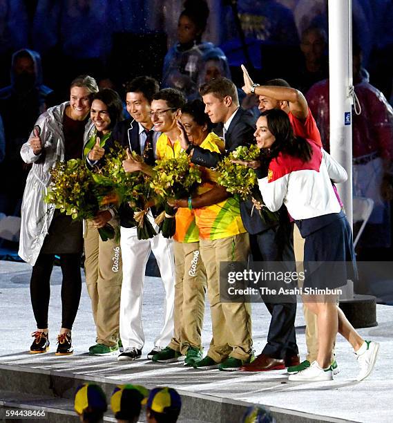 Newly elected IOC Atheltes' Commission members pose for photographs with volunteer workers during the Closing Ceremony on Day 16 of the Rio 2016...