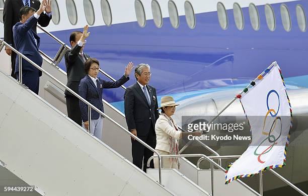 Tokyo Gov. Yuriko Koike arrives at Tokyo's Haneda airport with the Olympic flag on Aug. 24 after visiting Rio de Janeiro to attend the Summer Games...