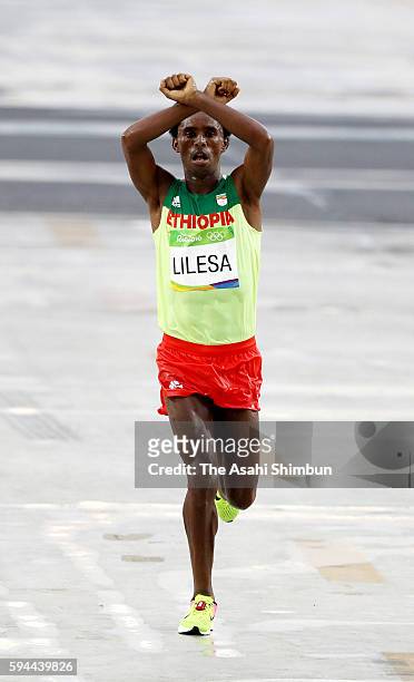 Feyisa Lilesa of Ethiopia crosses the line to win silver medal in the Men's Marathon on Day 16 of the Rio 2016 Olympic Games at Sambodromo on August...