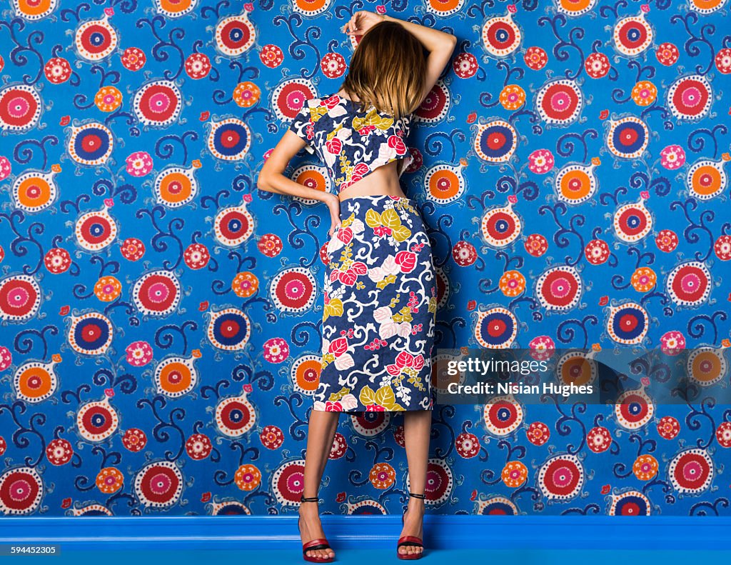 Woman wearing print dress against print background