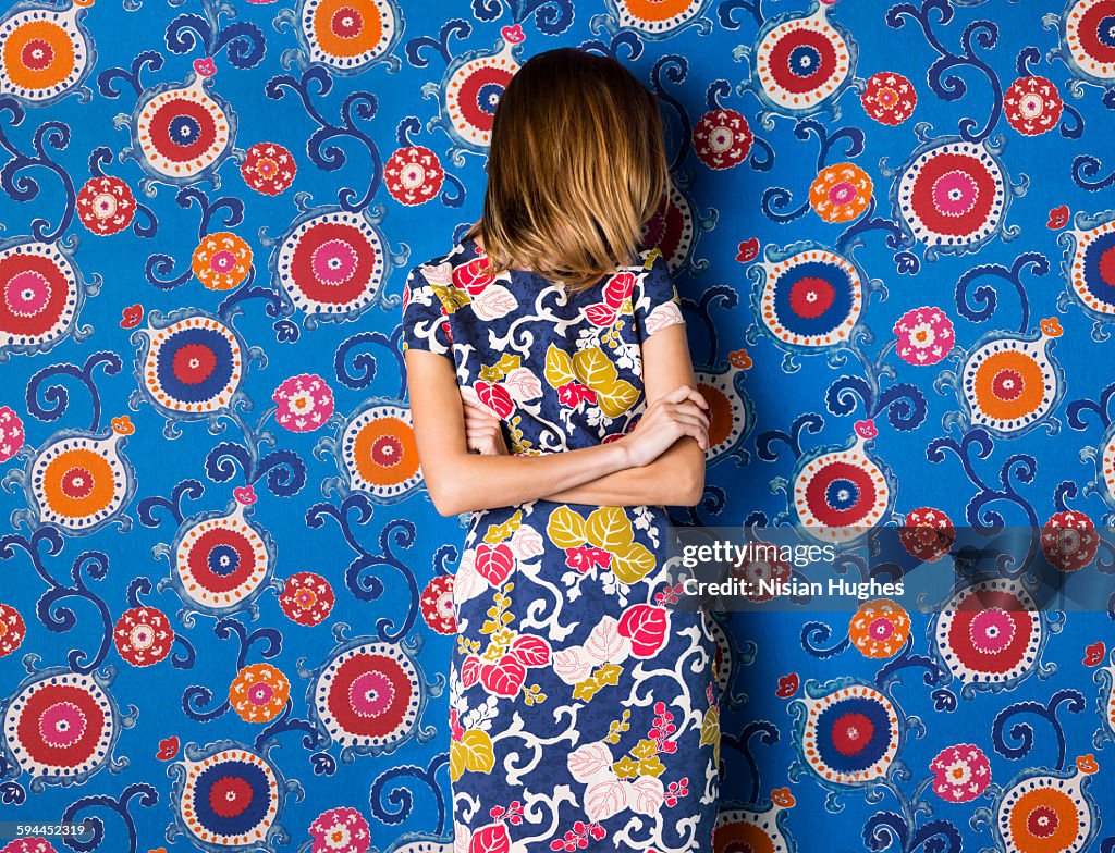 Woman wearing print dress against print background