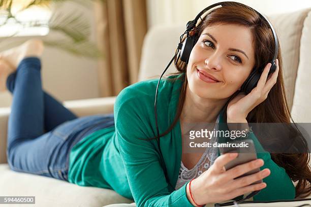 attractive young woman with headphones listens music on smartpho - free images without copyright stock pictures, royalty-free photos & images
