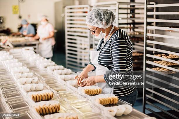 frau arbeitet bei bakery workshop - grundnahrungsmittel stock-fotos und bilder