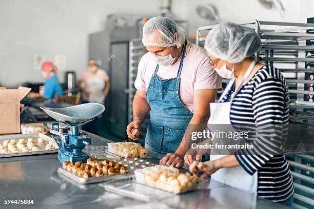 lavoratori che riempiono gli ordini presso bakery workshop - maschera di protezione per lo sport foto e immagini stock