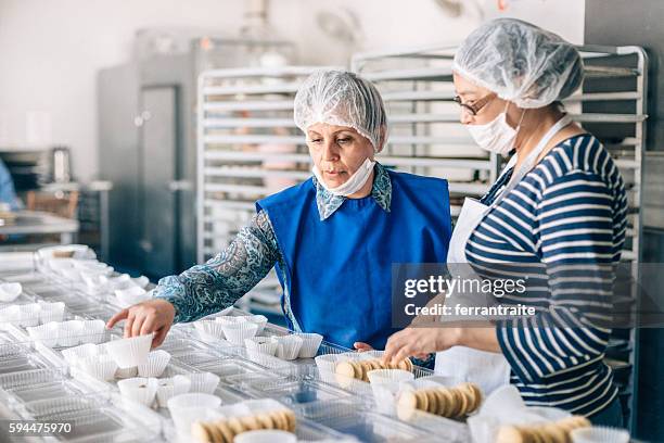 mujeres trabajando juntas en el taller de panadería - flu mask in mexico fotografías e imágenes de stock