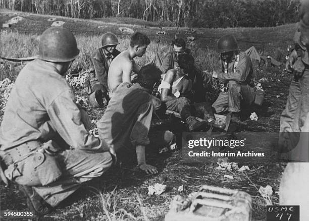 Navy chaplain attached to a Marine unit gives first aid and comfort to a wounded Marine while under fire on the front lines west of the Matanikau...