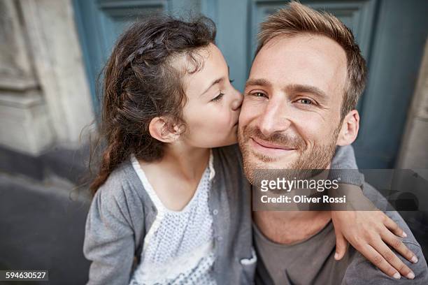 daughter kissing smiling father outdoors - six year old stock pictures, royalty-free photos & images