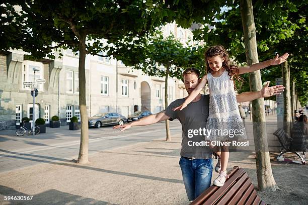 father with daughter balancing on a bench - balance family stock pictures, royalty-free photos & images