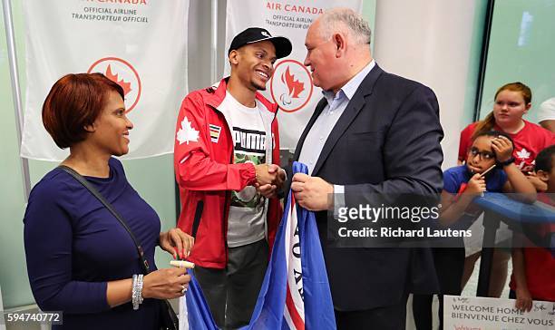 Triple medallist, sprinter and Markham resident Andre De Grasse is greeted by Markham Mayor Frank Scarpitti and his mom, Beverley. Plane loads of...
