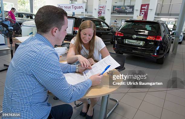 Car sales conversation between a seller and a customer female in a Volkswagen car dealer in Bonn