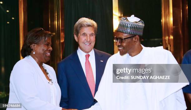 United States Secretary of State John Kerry smiles as Nigerian President Muhammadu Buhari shakes hands with US Assistant Secretary of State for...