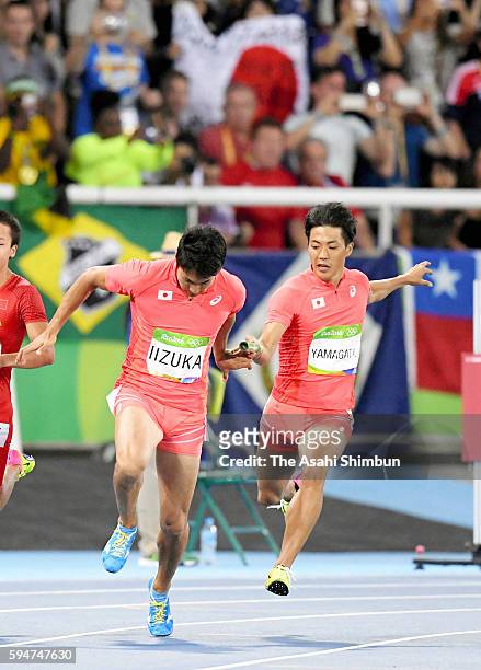 First runner Ryota Yamagata passes the baton to second runner Shota Iizuka of Japan in the Men's 4x100m Relay final on day 14 of the Rio 2016 Olympic...