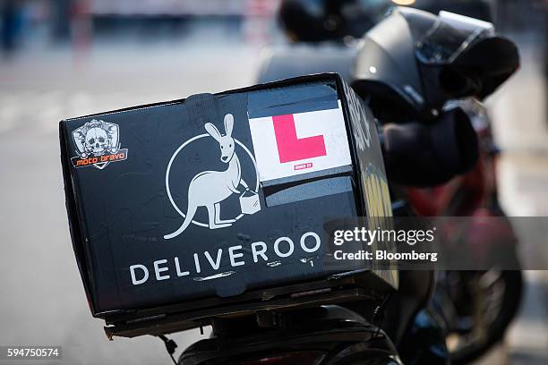 Food delivery box sits on the back of a Deliveroo, operated by Roofoods Ltd., driver's scooter parked on a street in London, U.K., on Monday, Aug....