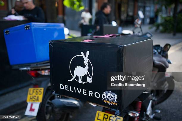 Food delivery box sits on the back of a Deliveroo, operated by Roofoods Ltd., driver's scooter parked on a street in London, U.K., on Monday, Aug....