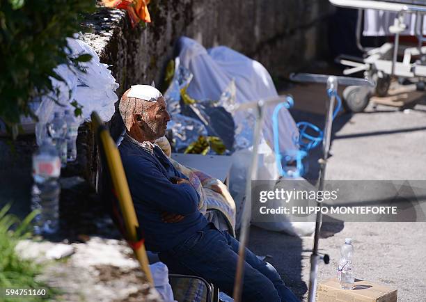 An injured man looks on after a strong earthquake hit his village, in Amatrice on August 24, 2016. A powerful 6.2-magnitude earthquake devastated...