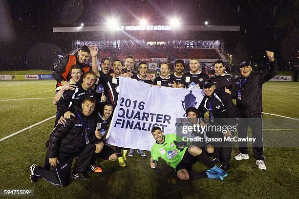 Blacktown players hold the quarter finalist banner after winning the round 16 FFA Cup match between Blacktown City and Bonnyrigg White Eagles at...