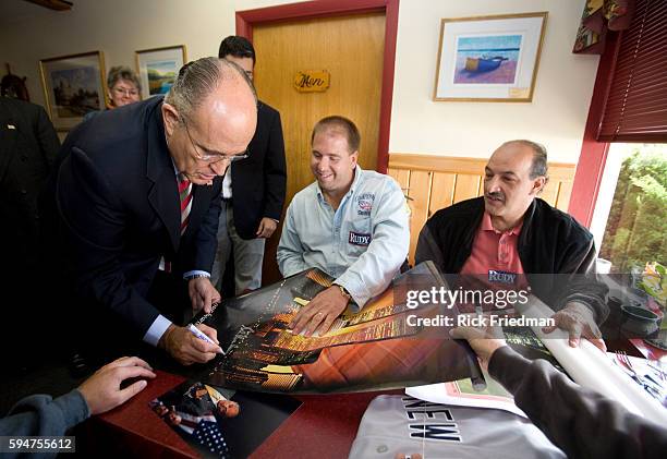 Republican presidential candidate Rudy Giuliani signs autographs while campaigning at the Golden Egg Restaurant in Portsmouth, New Hampshire.