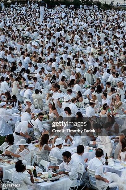 People attend Diner en Blanc , a pop-up dinner held once a year in New York on August 25, 2014 in the Battery Park City neighborhood of New York...