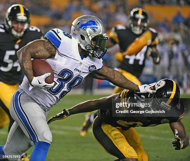 Running back Stevan Ridley of the Detroit Lions tries to avoid a tackle by cornerback Doran Grant of the Pittsburgh Steelers as he runs with the...