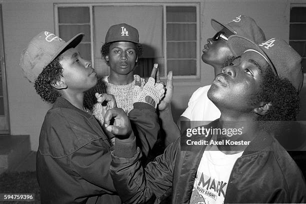 Members of the Grape Street Crips pose "throwing" their signature 'G' and 'W' hand signs. The Grape Street Watts Crips are a mostly African American...