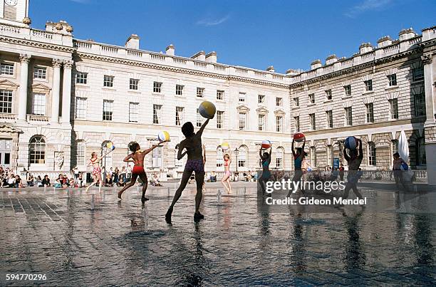 Dancers from the Aletta Collins Dance Company toss beach balls as they perform 'Kool Down' a playful interaction with the choreographed fountains of...