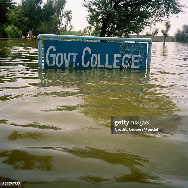 The sign outside the government college in Johi is almost submerged by floodwaters. This educational building is one of thousands of schools and...