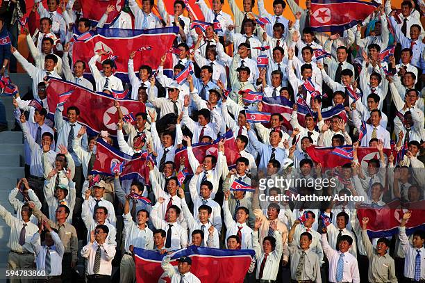 Fans of North Korea sit watching the Asian Cup 2011, Group D match Iran v North Korea wearing shirt and ties