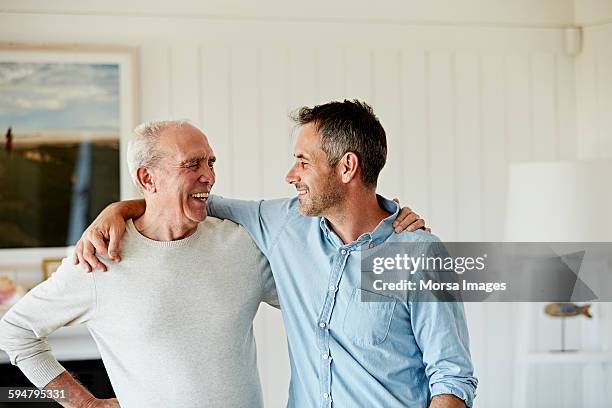 happy father and son at home - arm umlegen stock-fotos und bilder