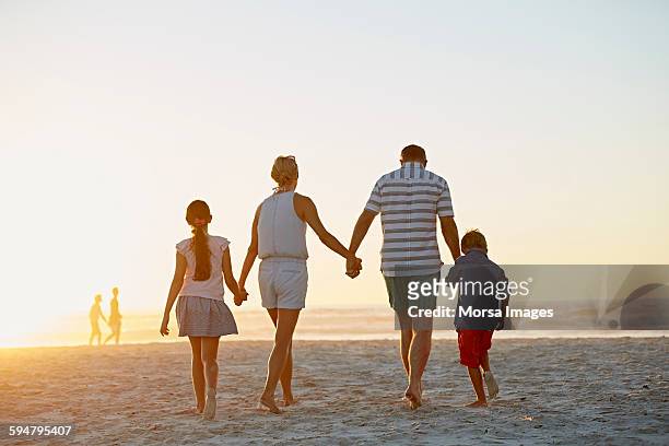 family walking on beach - beach vacation stock pictures, royalty-free photos & images